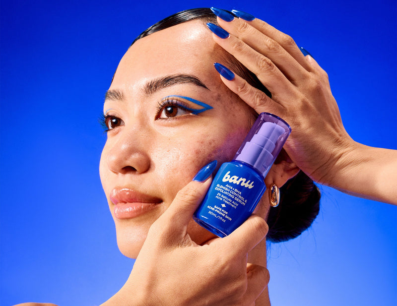 girl holding up blemish control & exfoliating serum